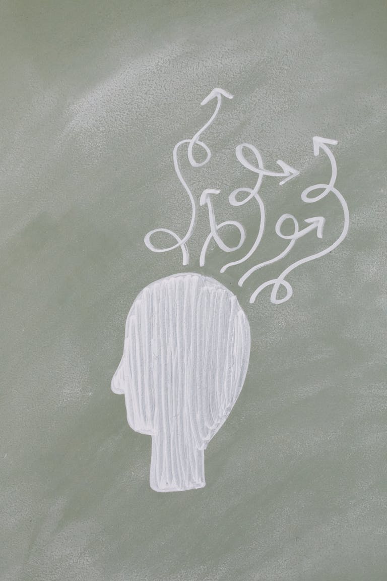 Chalk outline of a head with swirling arrows depicting abstract thinking on a chalkboard.