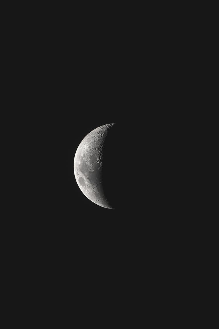 A detailed view of the crescent moon set against a dark night sky, showcasing lunar texture.