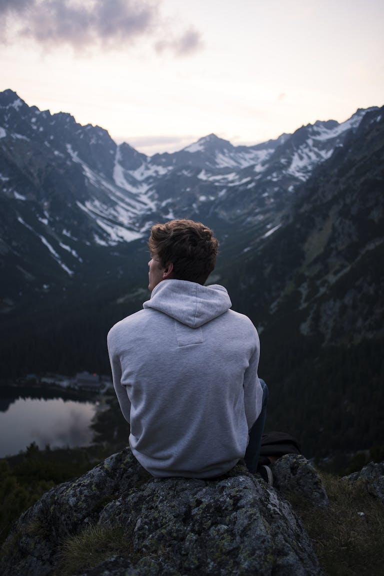 A person enjoying a serene mountain view at twilight, embracing solitude and adventure.