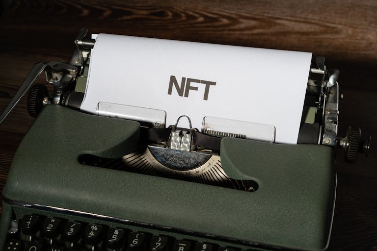 Close-up of a vintage typewriter with the word 'NFT' typed on paper, symbolizing digital innovation.