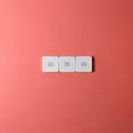 Close-up of WWW keyboard keys on a vibrant red surface, ideal for digital concepts.