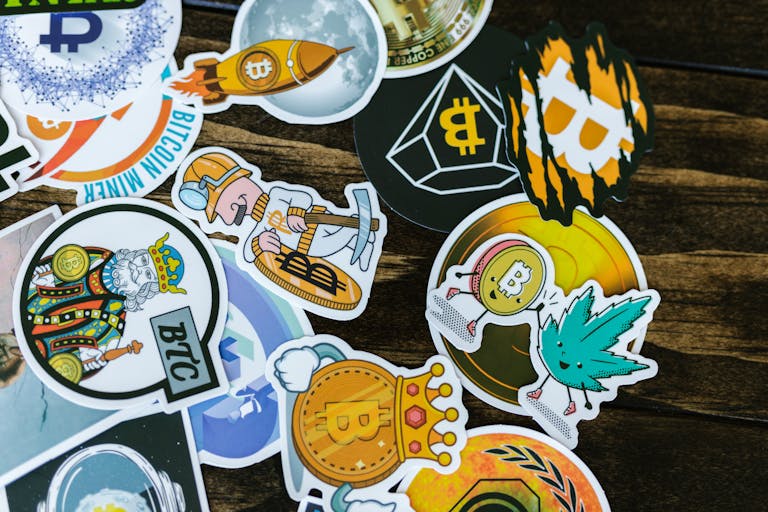Colorful stickers featuring Bitcoin and cryptocurrency themes on a wooden surface.