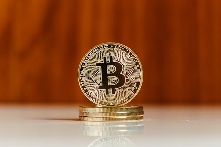 Golden bitcoin coin standing on stack. Ideal for cryptocurrency and blockchain illustrations.