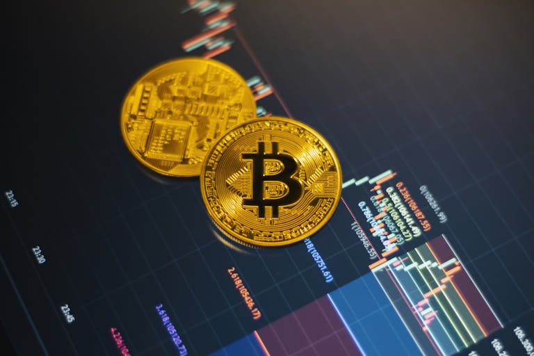 Golden Bitcoin coins on a digital stock market chart showcasing cryptocurrency trading.