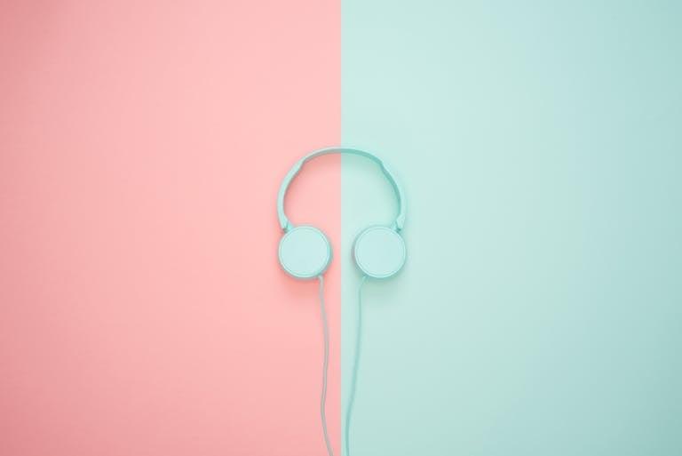 Minimalist headphones on a pink and mint background, artistic and modern.