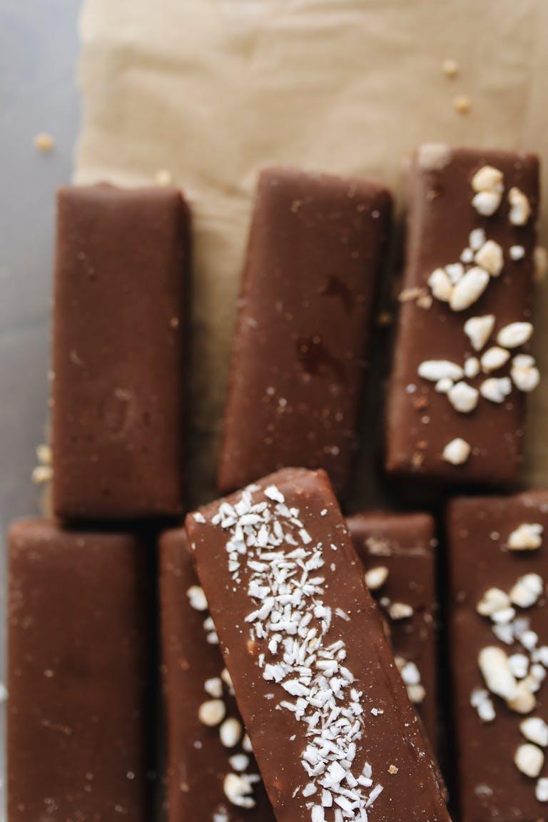 Delicious homemade chocolate bars topped with nuts and coconut flakes for a sweet indulgence.
